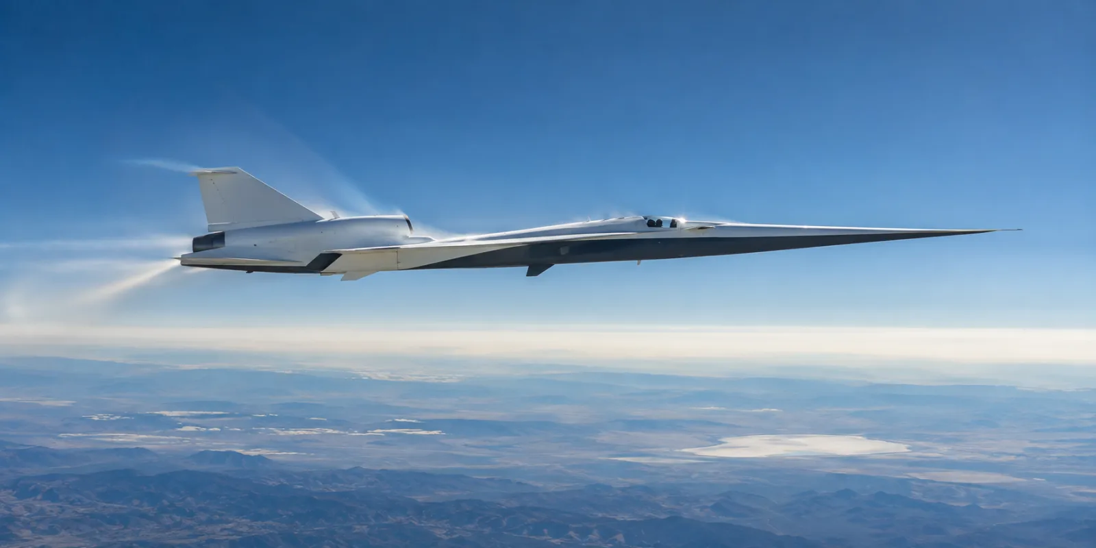 Das experimentelle Überschall-Forschungsflugzeug X-59 fliegt über einer dunstigen Landschaft unter blauem Himmel.