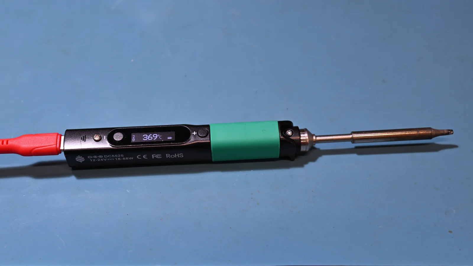 Soldador inteligente USB-C de la clase Pinecil sobre una alfombrilla de trabajo; foto real usada como ejemplo de categoría, no como prueba de autenticidad de clones.