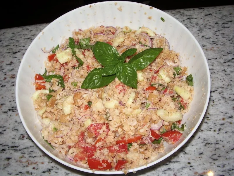 Schüssel Panzanella beim Mischen von Brot und Gemüse