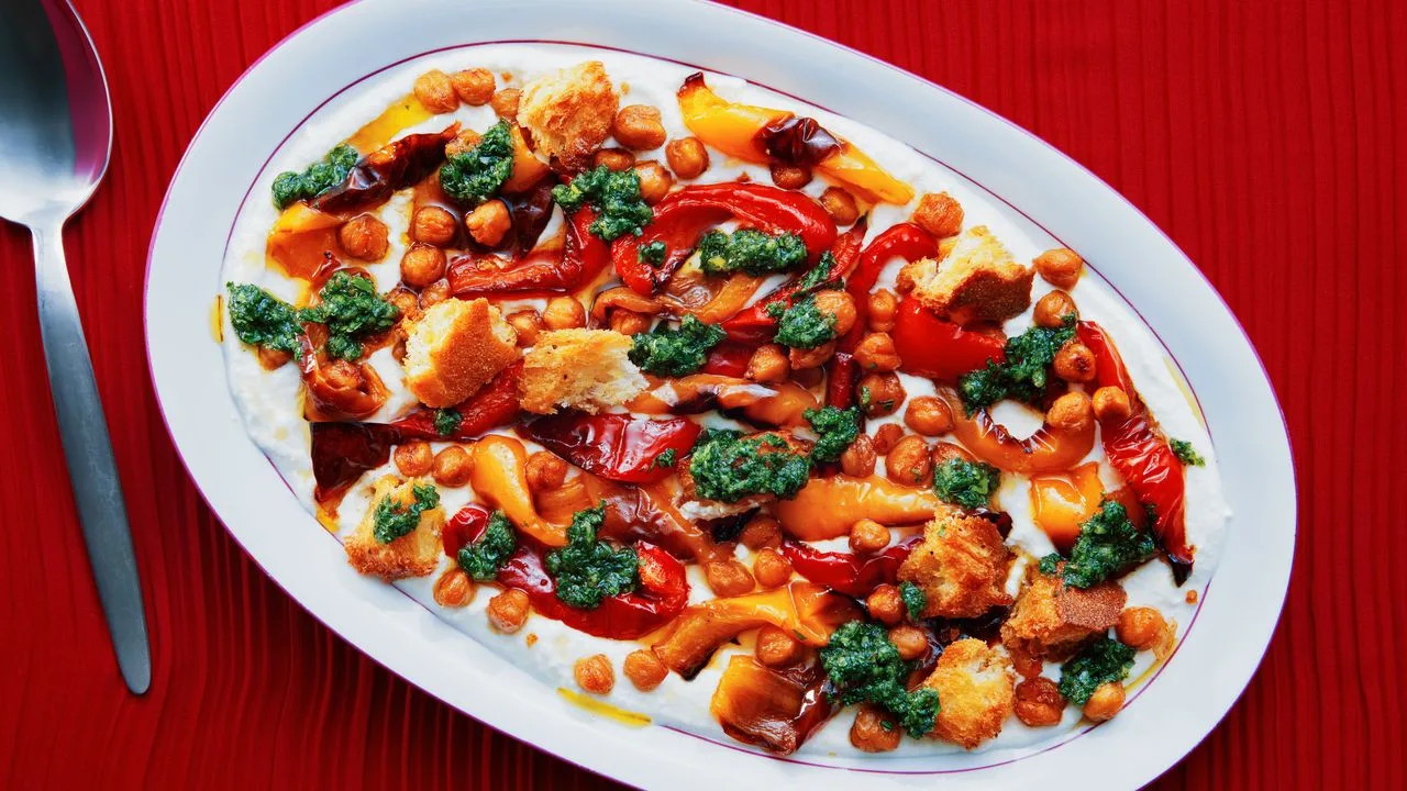 A colorful sheet-pan dinner of roasted corn, peppers, onions and chickpeas with yogurt sauce and a crunchy topping.
