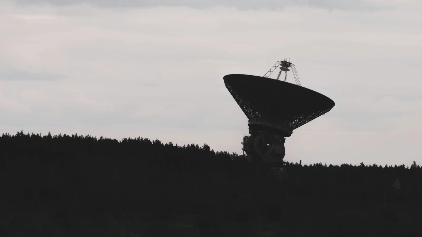 Radio telescope silhouetted against the sky